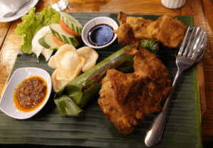 Nasi timbel khas Sunda yang disajikan dengan ayam goreng, tahu, tempe, lalapan, dan sambal, makanan tradisional populer di Bandung.